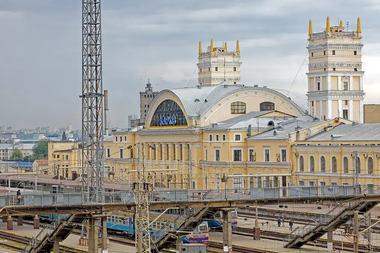 Жовта вокзальна будівля Харків-Пасажирського з двома вежами над коліями, платформами й контактною мережею